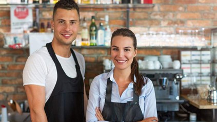 Mann und Frau mit Schürze in Küche