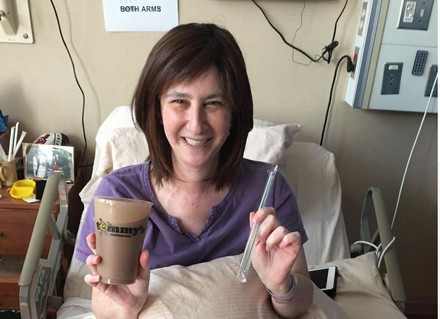 Frau mit Milchshake in Krankenhausbett