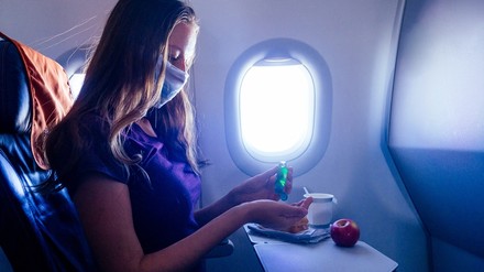 Eine Frau bei Hygienemaßnahmen im Flugzeug