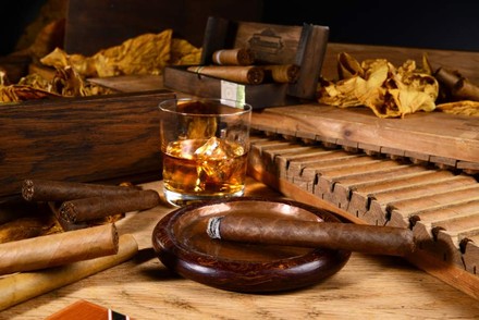 Kubanische Zigarre in Aschenbecher und Rum in Glas