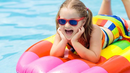 Ein Kind auf einer Luftmatratze in einem Hotel-Swimmingpool