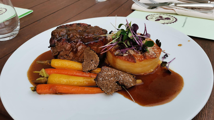 Teller mit Rosa Filet vom Rind, dazu Kartoffel Gratin, Baby Karotten, Knochenmarkjus und Sommer-Trüffel.