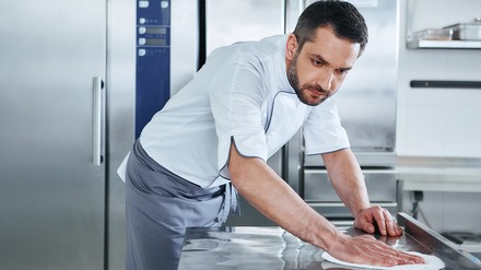 Mann putzt die Gastronomie-Küche