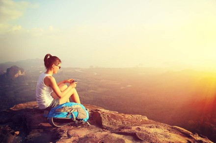 Frau fotografiert Panorama auf Bergspitze