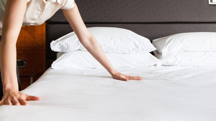 Frau richtet das Hotelbett her