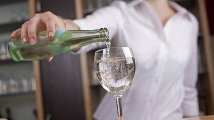 Wirtin gießt Wasser in Glas
