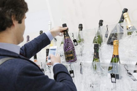 Ein Mann Fotografiert im Rahmen der Champagner-Lounge eine Flasche Champagner