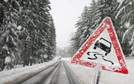 Warnschild auf Schneefahrbahn