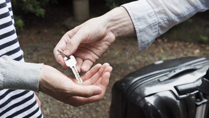 Mann übergibt Wohnungsschlüssel an Touristen