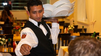 Kellner sammelt Teller ein